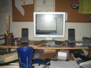 Two black computer speakers next to a white monitor.
