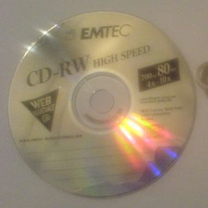 A small shiny reflective plastic disk with a hole in the middle. Written on it: Emtec, CD-RW High Speed, Web Assistance @ (illegible website). 700 (illegible) 80 (illegible). 4x-10x.