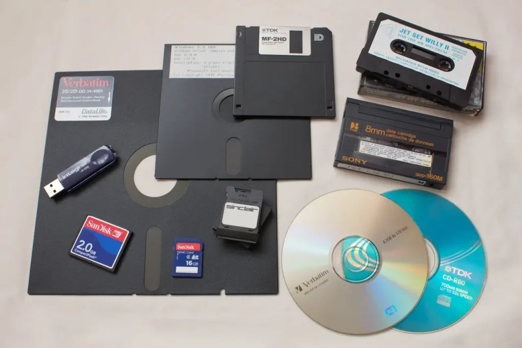 A photo featuring floppy disks of various sizes, a CD, a DVD, memory cards, and tapes.